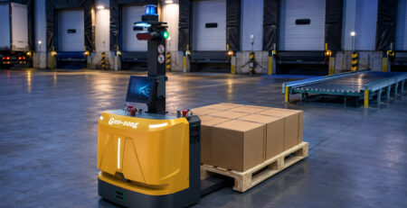 Autonomous pallet transport robot carrying boxes near warehouse loading docks