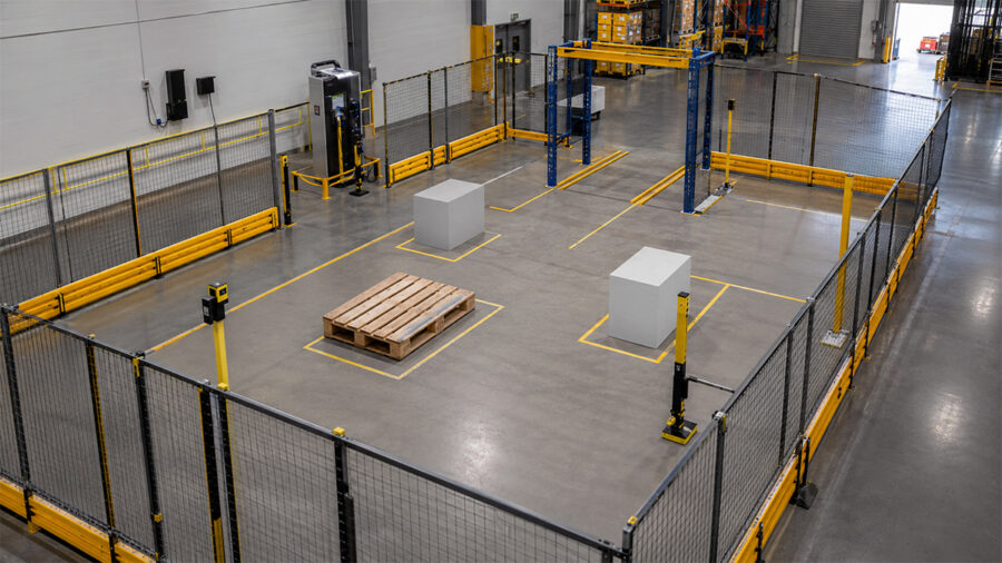 Fenced warehouse test area with a pallet, scanners and marked lanes