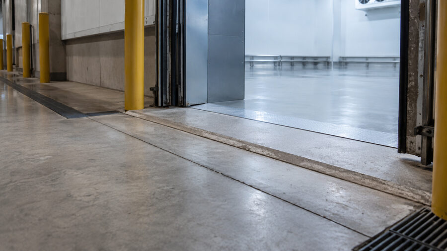 Warehouse doorway with a concrete threshold and yellow protective bollards